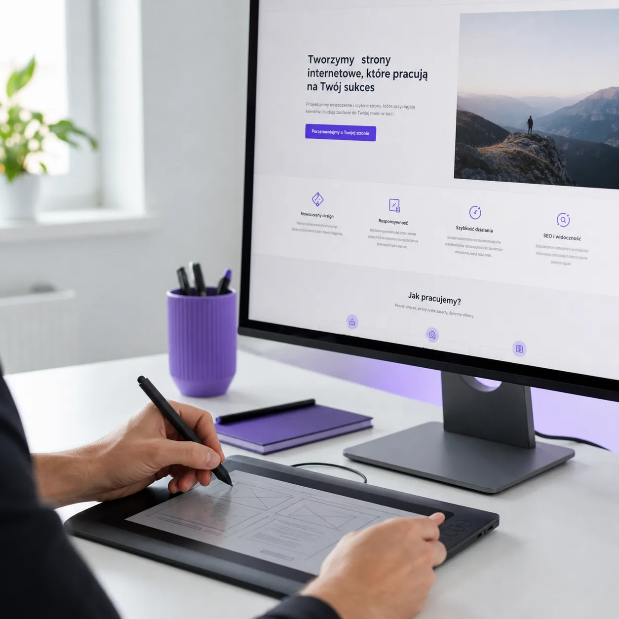 Projektant szkicuje układ strony internetowej na tablecie graficznym